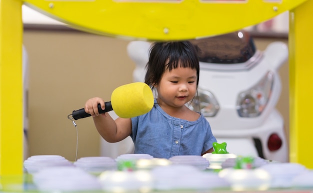 Petite fille jouant au terrain de jeu et amusant avec le jeu