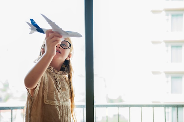 Petite fille jouant avec un avion jouet