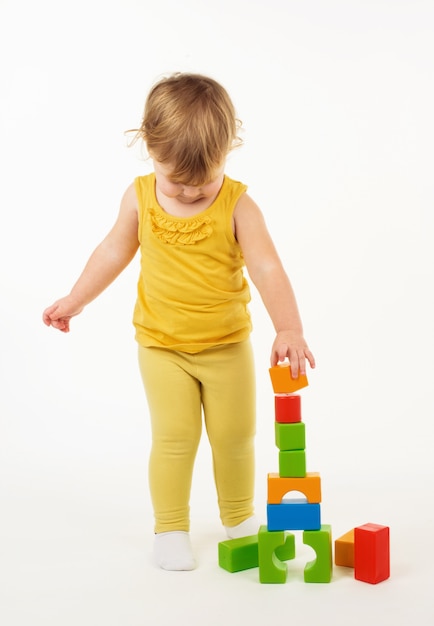 Petite fille jouant avec des blocs de jouets colorés