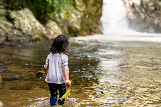 Petite fille jouant à la cascade pendant les vacances d'été