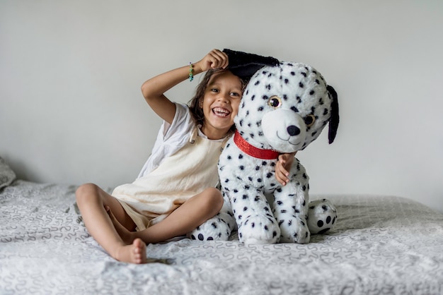 Petite fille jouant avec un chien en peluche