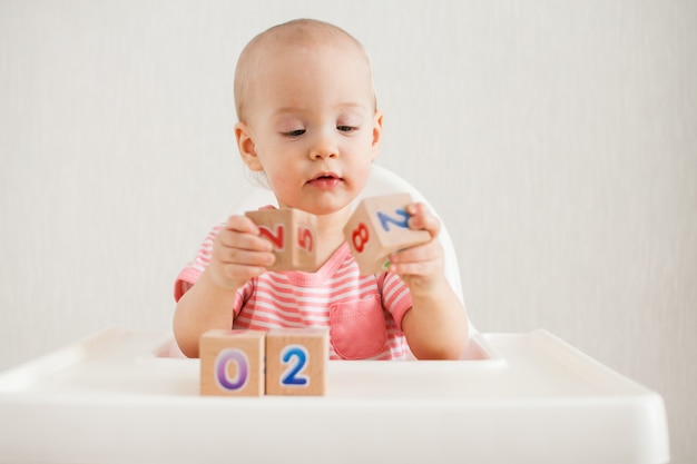 Petite fille jouant avec des cubes en bois avec des nombres lumineux 2022