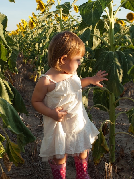 Petite fille jouant dans le champ de tournesol.