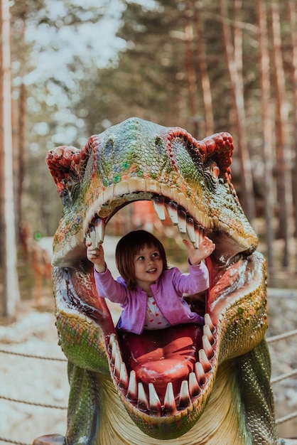 Photo une petite fille jouant dans le parc. le concept de socialisation familiale dans le parc. une fille se balance sur une balançoire, joue à des jeux créatifs.