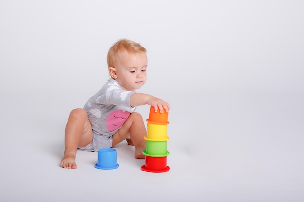 Petite fille jouant avec des jouets éducatifs sur un fond blanc