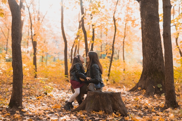 Petite fille jouant avec sa mère dans le parc en automne