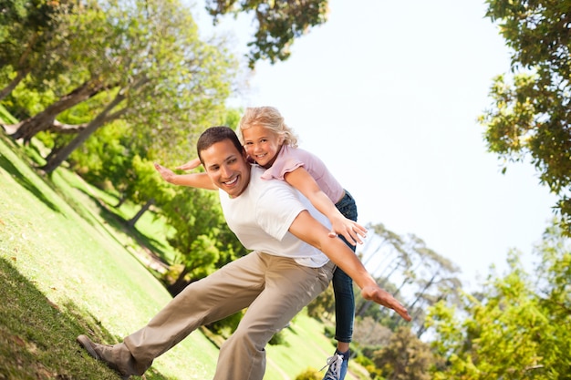 Petite fille jouant avec son père dans le parc