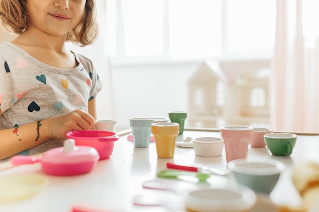 Petite fille jouant de la vaisselle pour enfants