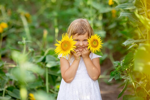 Une Petite Fille Joue Avec Des Fleurs De Tournesol Dans Un Champ De Tournesols