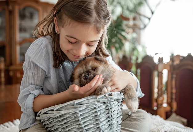 Une petite fille joue avec son petit chiot moelleux