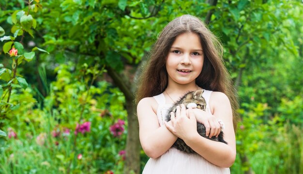 Petite fille jouer avec mignon chaton chat nature fond ludique enfant concept