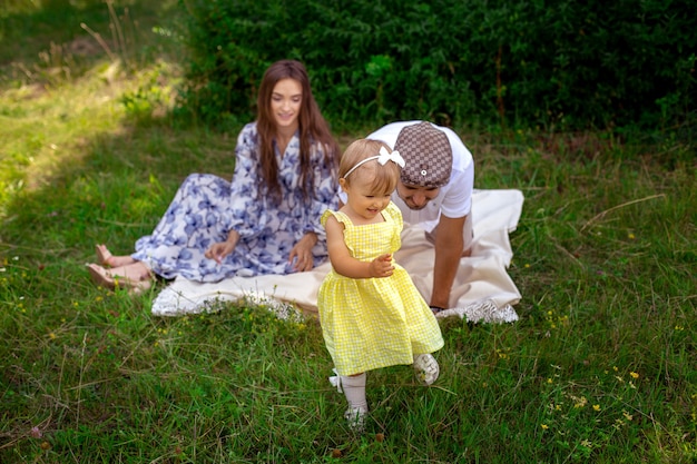 Une petite fille joyeuse manque de ses parents à l'heure du pique-nique dans le jardin