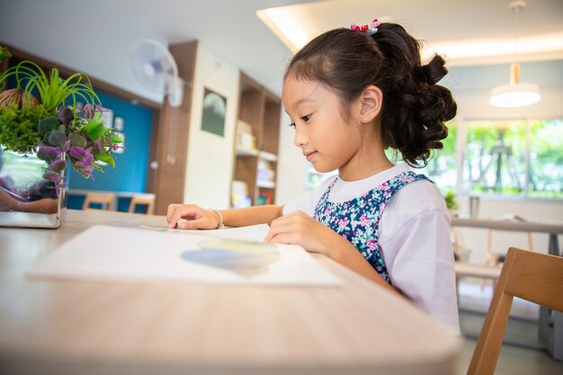 Petite fille lisant un livre à la bibliothèque de l&#39;école