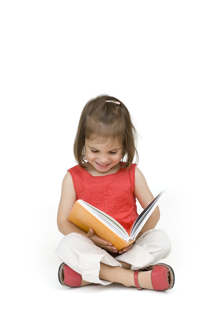Photo petite fille lisant un livre isolé