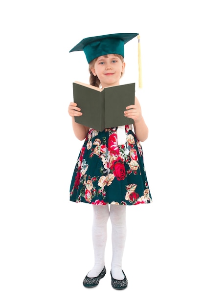 Petite fille avec un livre et portant un chapeau sur une surface blanche