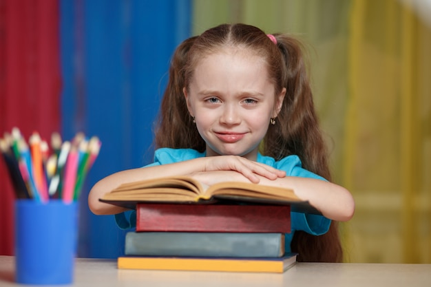 Petite fille avec des livres à l'école