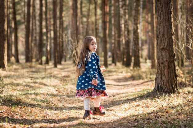 petite fille longe un chemin forestier