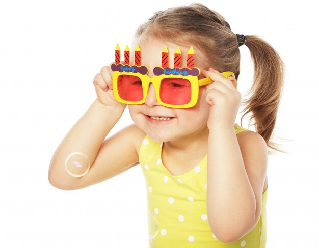 petite fille avec des lunettes de carnaval orange amusant