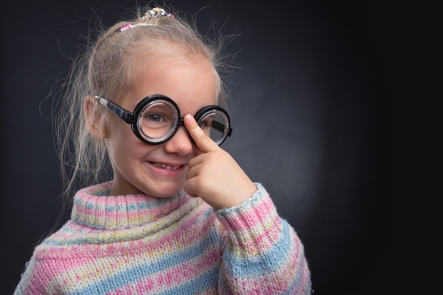 Petite fille à lunettes fait des grimaces