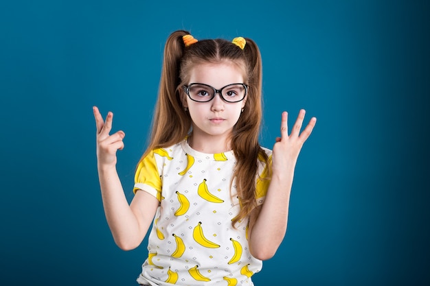 Petite fille à lunettes et T-shirt avec des bananes