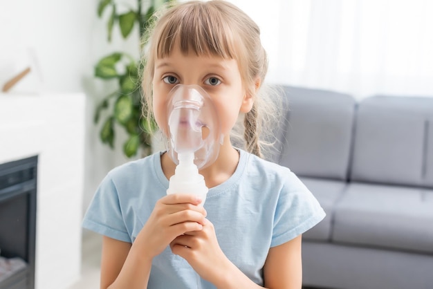 petite fille malade fait l'inhalation sur fond gris avec espace de copie. Fille faisant l'inhalation avec nébuliseur à la maison. enfant asthme inhalateur inhalation nébuliseur vapeur malade toux.