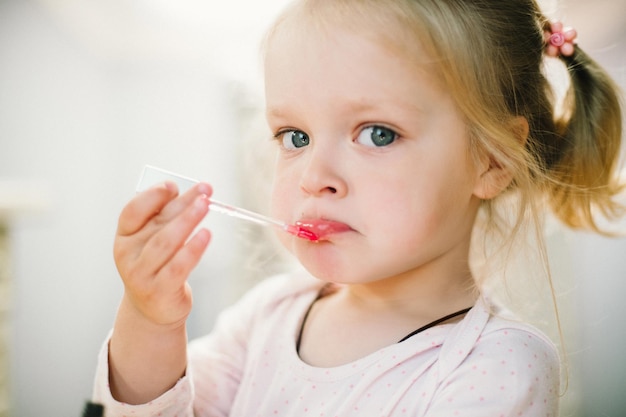 Petite fille et maman peignant le maquillage près de la coiffeuse