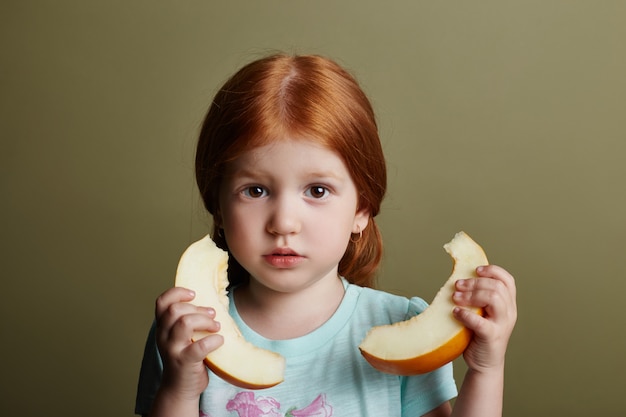 Petite fille mange un melon