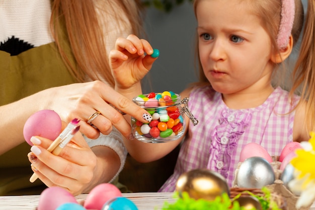 Petite fille mangeant des bonbons de Pâques colorés se bouchent