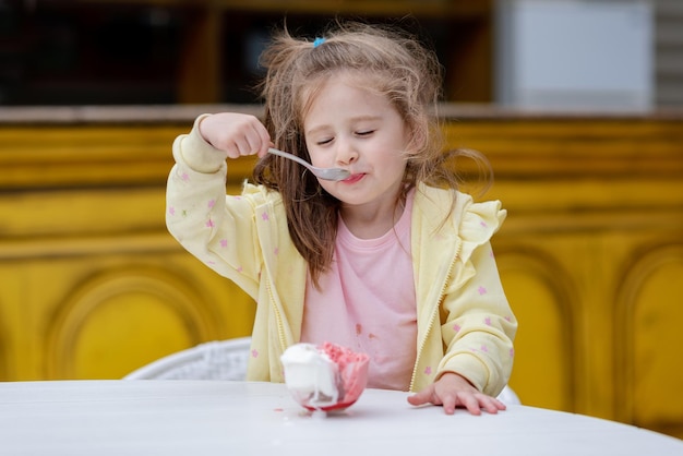 Une petite fille mangeant de la glace avec une cuillerée de glace.