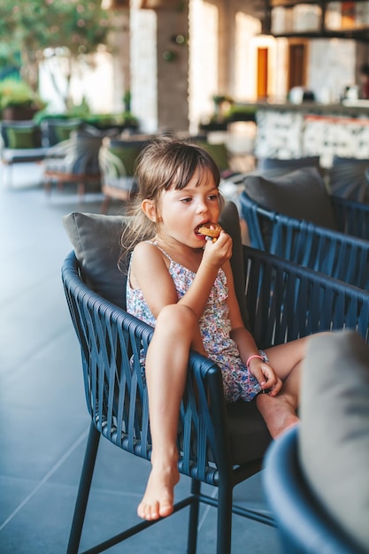 Petite fille mangeant des rondelles d'oignon