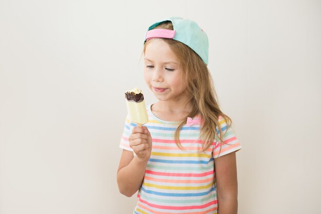 Petite fille, manger des glaces sucrées sur un bâton