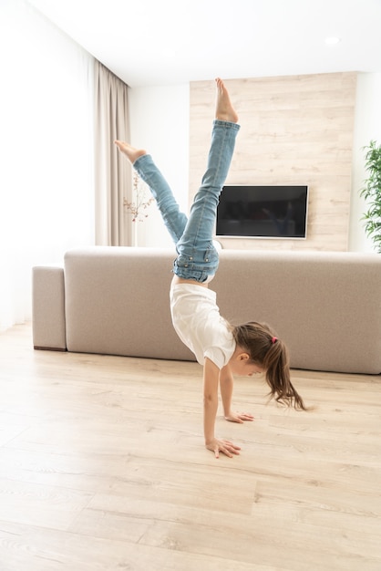 Petite fille marchant la tête en bas sur ses bras à la maison