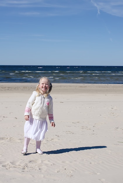 La petite fille marche sur la plage