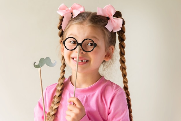 Petite fille avec des masques de déguisements pour la fête des pères.