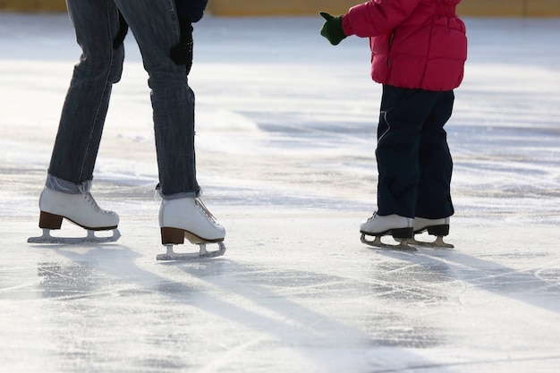 Petite fille avec mère patiner sur la patinoire