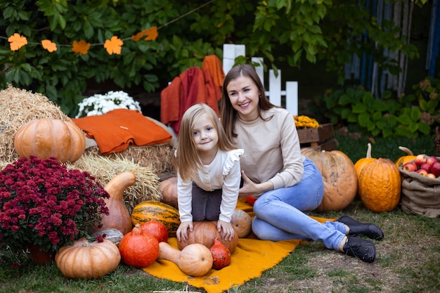 Petite fille et mère profitant de la fête de la récolte au potiron