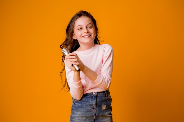 petite fille avec microphone souriant chantant