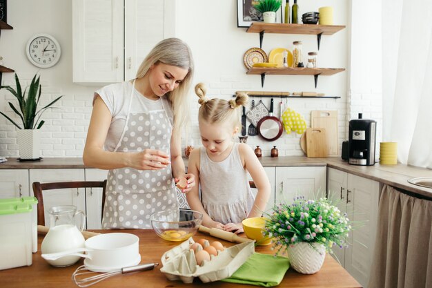 Une petite fille mignonne aide maman à faire des biscuits dans la cuisine. Famille heureuse. Tonifiant.