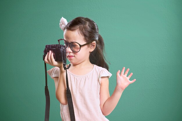 Petite fille mignonne asiatique selfie avec appareil photo rétro Vintage fond de mur vert menthe