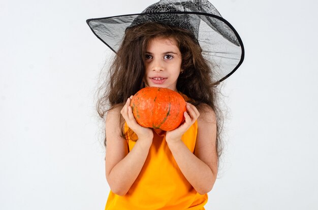 Petite fille mignonne dans un chapeau de sorcière Broom Pumpkin Heluin Place pour le texte