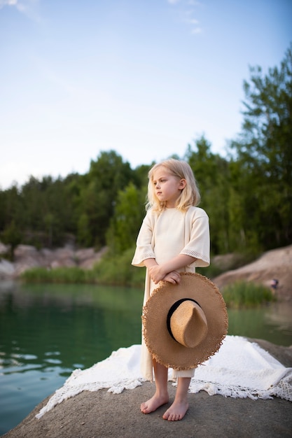 Petite fille mignonne dans des vêtements élégants dans un paysage de nature