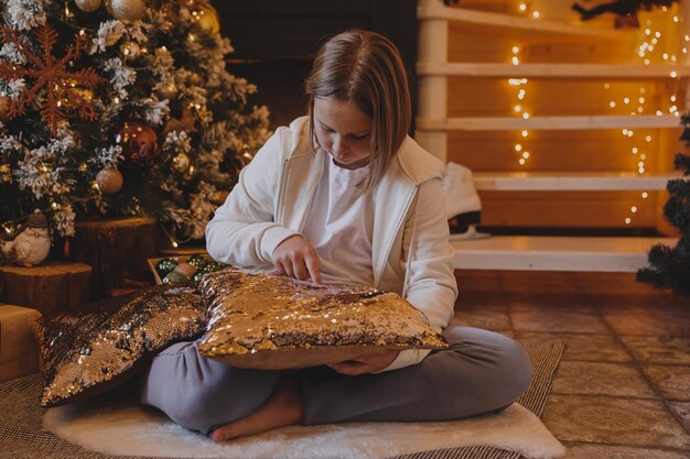 La petite fille mignonne décore un arbre de Noël. Joyeuses fêtes de Noël et du nouvel an.