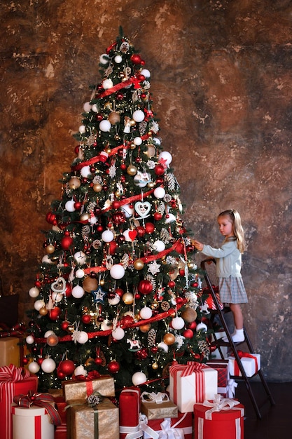 Petite fille mignonne décore le sapin de Noël Noël et nouvel an