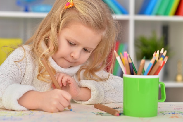 Petite fille mignonne dessinant avec des crayons colorés