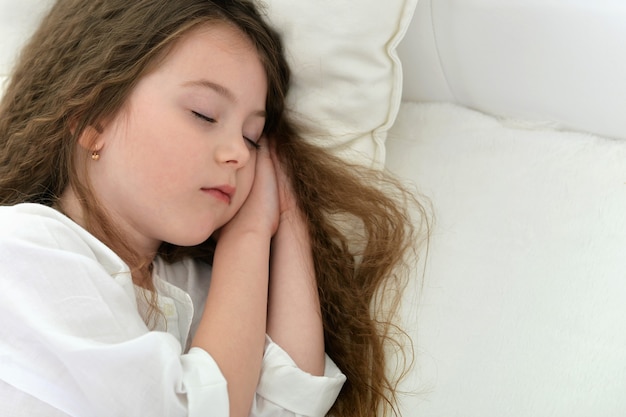 Petite fille mignonne dormant dans un lit