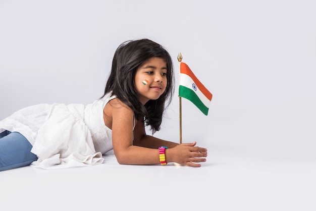 Petite fille mignonne avec le drapeau tricolore national indien, d'isolement sur le fond blanc. Convient pour le concept de la fête de l'indépendance ou de la fête de la République