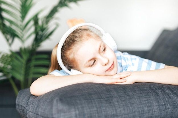 Petite fille mignonne écoutant la musique dans des écouteurs