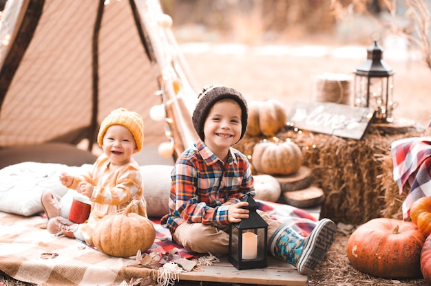 Petite fille mignonne avec un garçon enfant buvant du thé chaud avec un décor d'automne