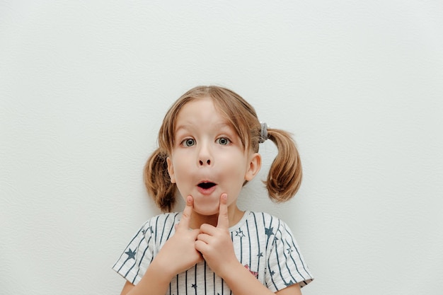 Petite fille mignonne avec de grands beaux yeux Studio shot minimalisme de fond blanc