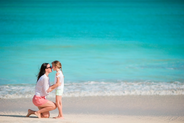 Petite fille mignonne et jeune maman à la plage tropicale